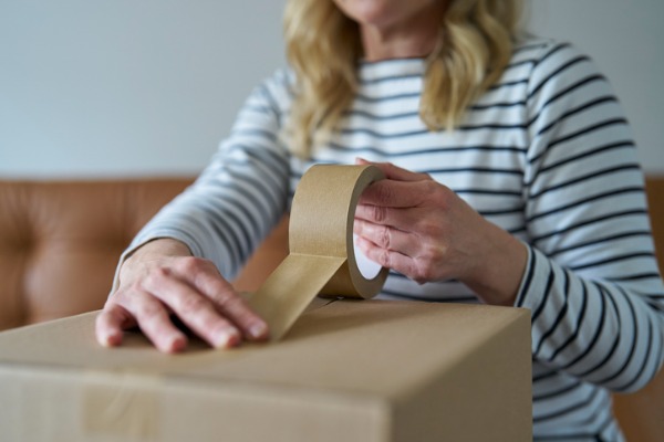 woman taping a box with paper tape