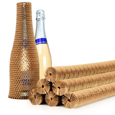 Rolls of honeycomb paper bottle sleeves, with one unwrapped glass bottle and one wrapped glass bottle