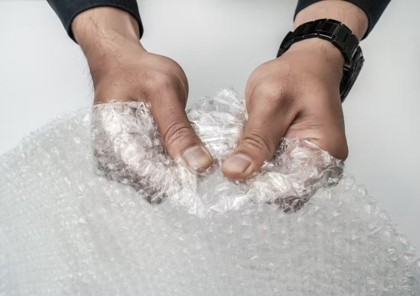 A person holding a bubble wrap in their hands.