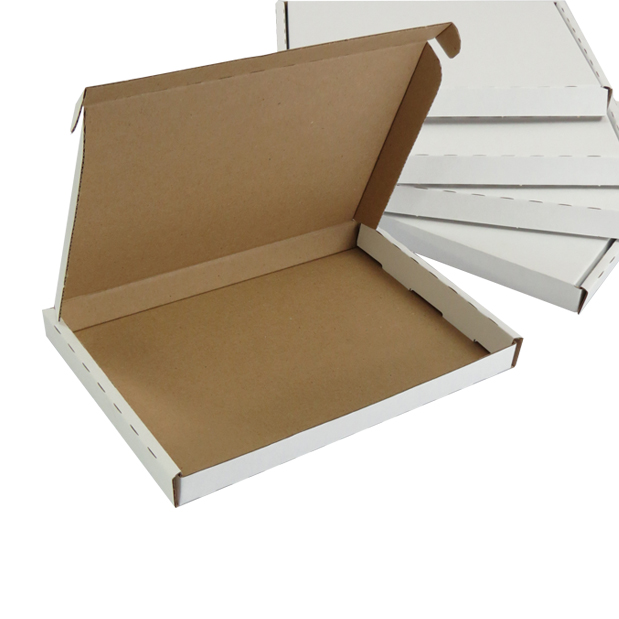 Open white large letter box with a brown interior, alongside a stack of flat-packed boxes ready for posting small orders.